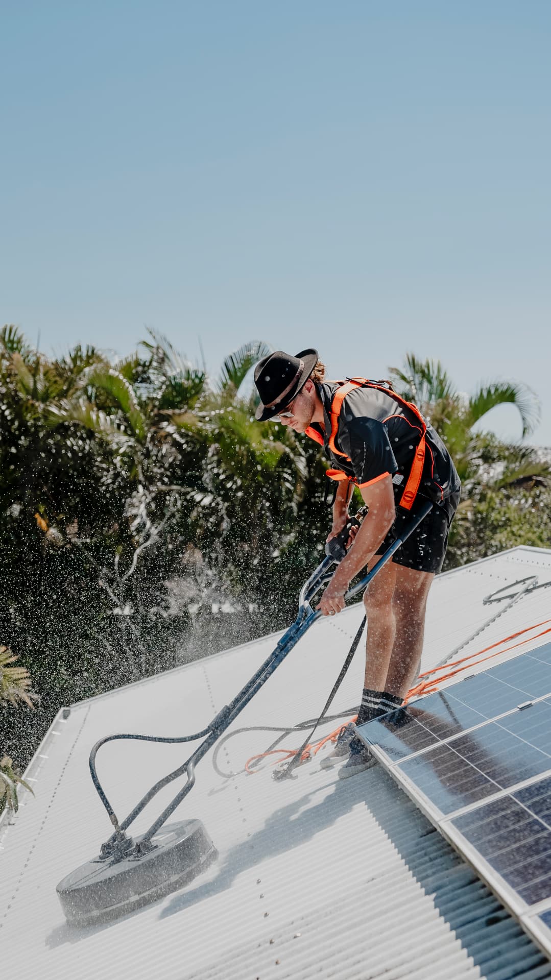 No Pressure Sunshine Coast technician soft washing a roof and solar panels